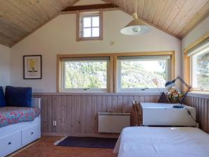 a bedroom with a bed and a sink and two windows at 5 person holiday home in MUNKEDAL in Munkedal