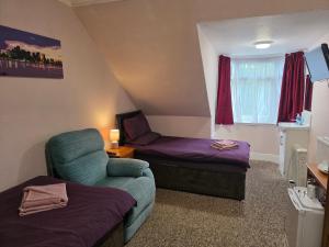 a small room with a couch and a chair at Station View Guest House in Dyce