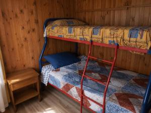 a room with two bunk beds and a table at El Urco Chiloé - Cabaña Guapilacuy in Ancud