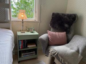 a bedroom with a chair and a lamp and a window at 6 person holiday home in 38472-By Traum in Tillingenabben