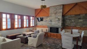 a living room with white chairs and a fireplace at Holiday Home Neochori Pelion in Neochori