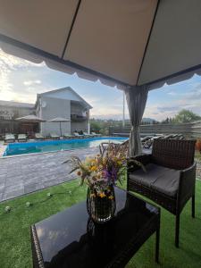 a patio with a couch and a table with flowers on it at Kvitkovyi Rai З червня басейн з підігрівом 10 на 5 метрів in Slavske