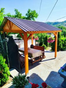a wooden gazebo with a table under it at Apartman Deni in Tuzla