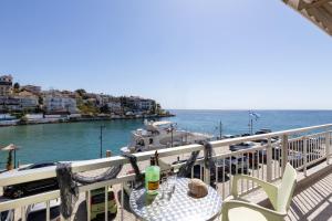 a balcony with a table and chairs next to the water at Cristels Studios 1 in Skala Marion