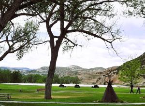 a picnic area with a tree and mountains in the background at Hot Springs Hotel & Spa in Thermopolis