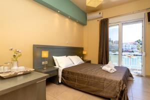 a hotel room with a bed and a large window at Cristels Studios 1 in Skala Marion +17 photos