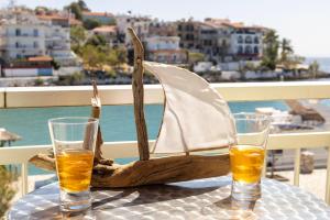 a table with two glasses of orange juice on a balcony at Cristels Studios 1 in Skala Marion
