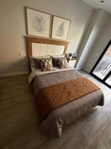 a bedroom with a large bed with two pictures on the wall at Apartamento Mediodía 3 in La Bañeza
