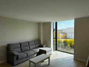 a living room with a couch and a large window at Apartamento Mediodía 3 in La Bañeza