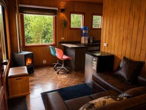 a living room with a couch and a stove at El Urco Chiloé - Cabaña La Fiura in Ancud