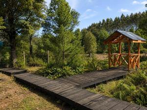 a wooden boardwalk with a gazebo in a park at El Urco Chiloé - Cabaña La Fiura in Ancud +6 photos
