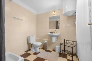 a bathroom with a toilet and a sink at Gery Apartman in Zamárdi +11 photos