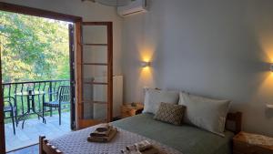 a bedroom with a bed and a balcony with a table at Holiday Home Neochori Pelion in Neochori