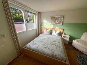 a small bedroom with a bed and a window at The Sleep Studio in Sint Annaland
