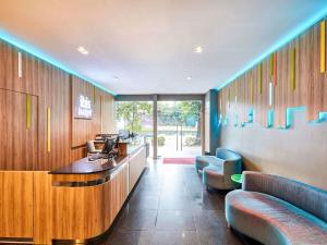 a waiting room with couches and a reception desk at ibis budget Singapore Bugis in Singapore