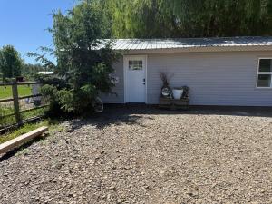 a small white house with a gravel driveway at Willow Pond Cabin in Ellensburg