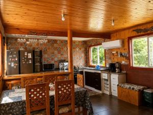 a kitchen with wooden walls and wooden ceiling at El Urco Chiloé - Hostal y Cabaña in Ancud