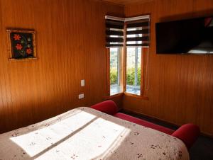 a room with a bed and a window and a table at El Urco Chiloé - Hostal y Cabaña in Ancud +1 photo