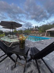 a table with an umbrella next to a swimming pool at Lemberg Apart З червня басейн з підігрівом 10 на 5 метрів in Slavske