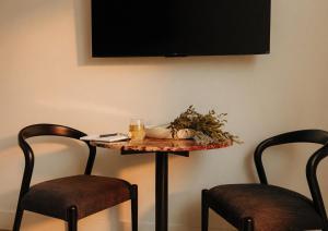 a table with two chairs and a tv on a wall at Ceros in Denver
