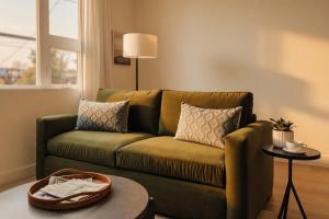 a living room with a green couch and a table at Ceros in Denver