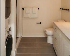 a bathroom with a toilet and a washer and dryer at Ceros in Denver +28 photos
