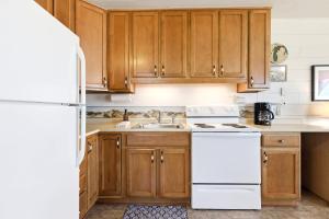 a kitchen with wooden cabinets and a white refrigerator at Chalet #20 in Stevensville