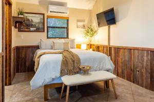 a bedroom with a bed with a chair and a tv at Nicole Creek Cabins in Waco