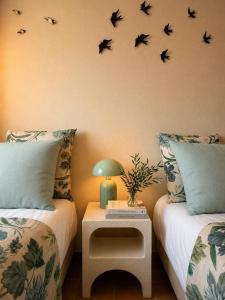 a bedroom with two beds with birds on the wall at Iconic Vila d'Obidos in Óbidos