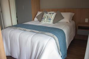 a bed with a blanket and pillows on it at Loft completo no Centro de Itaipava in Araras Petropolis +107 photos