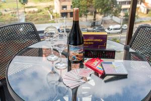 a glass table with a bottle of wine and two glasses at Loft completo no Centro de Itaipava in Araras Petropolis