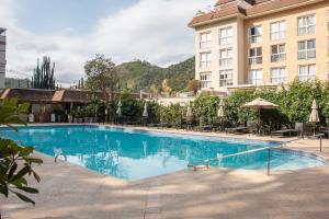 a large swimming pool in front of a hotel at Loft completo no Centro de Itaipava in Araras Petropolis