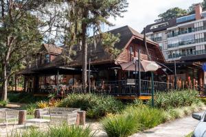 a house with an umbrella in front of a building at Loft completo no Centro de Itaipava in Araras Petropolis
