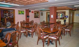 a dining room with wooden tables and chairs at Delfirm Hotel in Nairobi