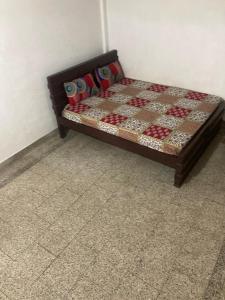 a bed sitting in a room with a checkerboard at sree thilak apartments in Guruvāyūr
