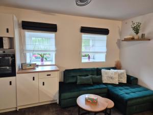 a living room with a green couch and a table at Apartmán U Lanovky in Kramolín