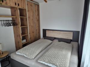 a bedroom with a bed with a wooden headboard at Apartmán U Lanovky in Kramolín +12 photos