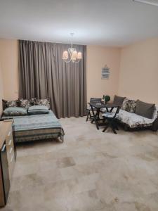 a bedroom with a bed and a table and a couch at Студио за гости БОРИСА in Kranevo +29 photos