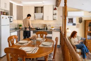 a man and a woman sitting at a table in a kitchen at El Triskel de Chumbea- Confort y naturaleza en la Sierra de Béjar in Navalmoral de Béjar +39 photos