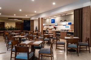 a restaurant with wooden tables and chairs and a counter at Holiday Inn Express Quito by IHG in Quito