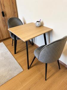 a wooden table and two chairs in a room at Harmónia Home in Miskolc