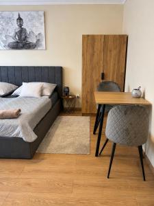a bedroom with a bed and a wooden table at Harmónia Home in Miskolc +4 photos
