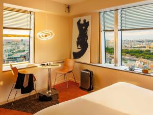 a room with a bed and a table and a window at Too Hotel & Spa Paris - MGallery Collection in Paris +134 photos