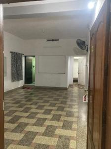 an empty room with a white wall and a checkered floor at sree thilak apartments in Guruvāyūr +1 photo