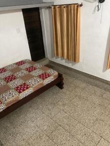 a bed sitting in a room with a curtain at sree thilak apartments in Guruvāyūr