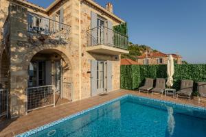 a villa with a swimming pool and a house at Aether Blue Eco Villas in Agios Nikolaos