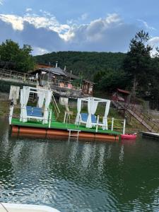a group of chairs on a boat in the water at Leo Green House in Cinciş
