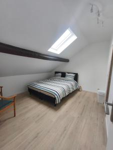 a bedroom with a bed and a skylight at Sisters home in Marcinelle