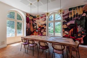 a dining room with a table and chairs and a mural at La Villa Kara in Romans-sur-Isère