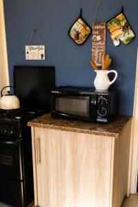 a microwave sitting on top of a counter in a kitchen at The Big Tree Cottage in Graafwater